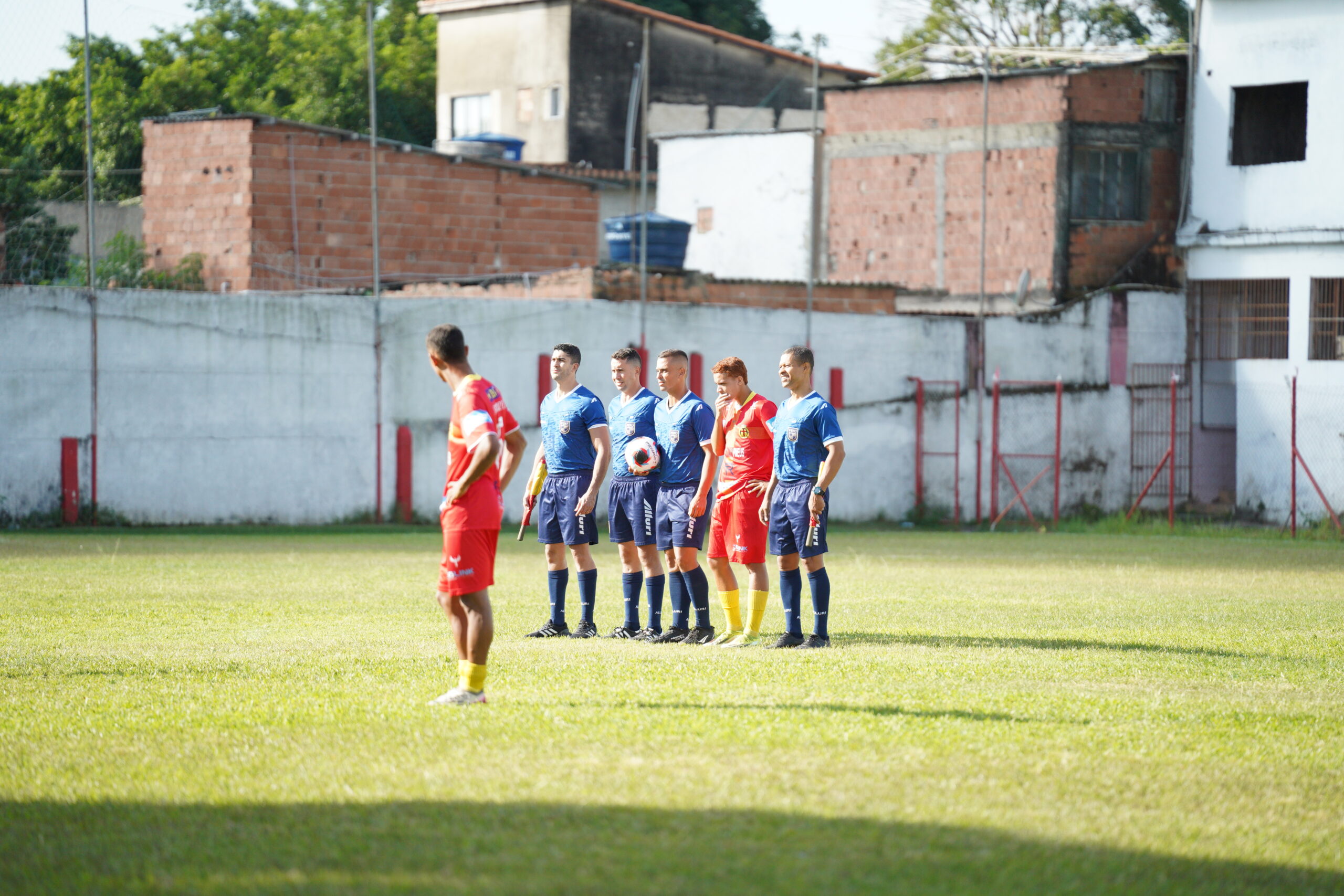 Formação protocolar dos árbitros e capitães no jogo entre Santa Cruz e Serra Macaense